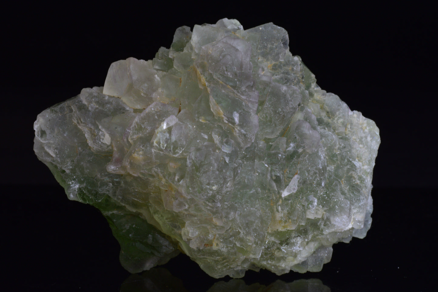 Green fluorite crystal from El Hammam, Morocco, with vibrant green hues, displayed on a neutral background.