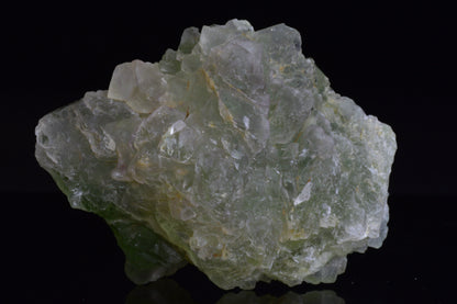 Green fluorite crystal from El Hammam, Morocco, with vibrant green hues, displayed on a neutral background.