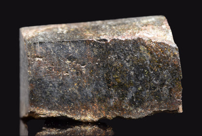 NWA 11757 Ureilite meteorite specimen showing dark fusion crust and crystalline interior, weighing 7.6 grams.