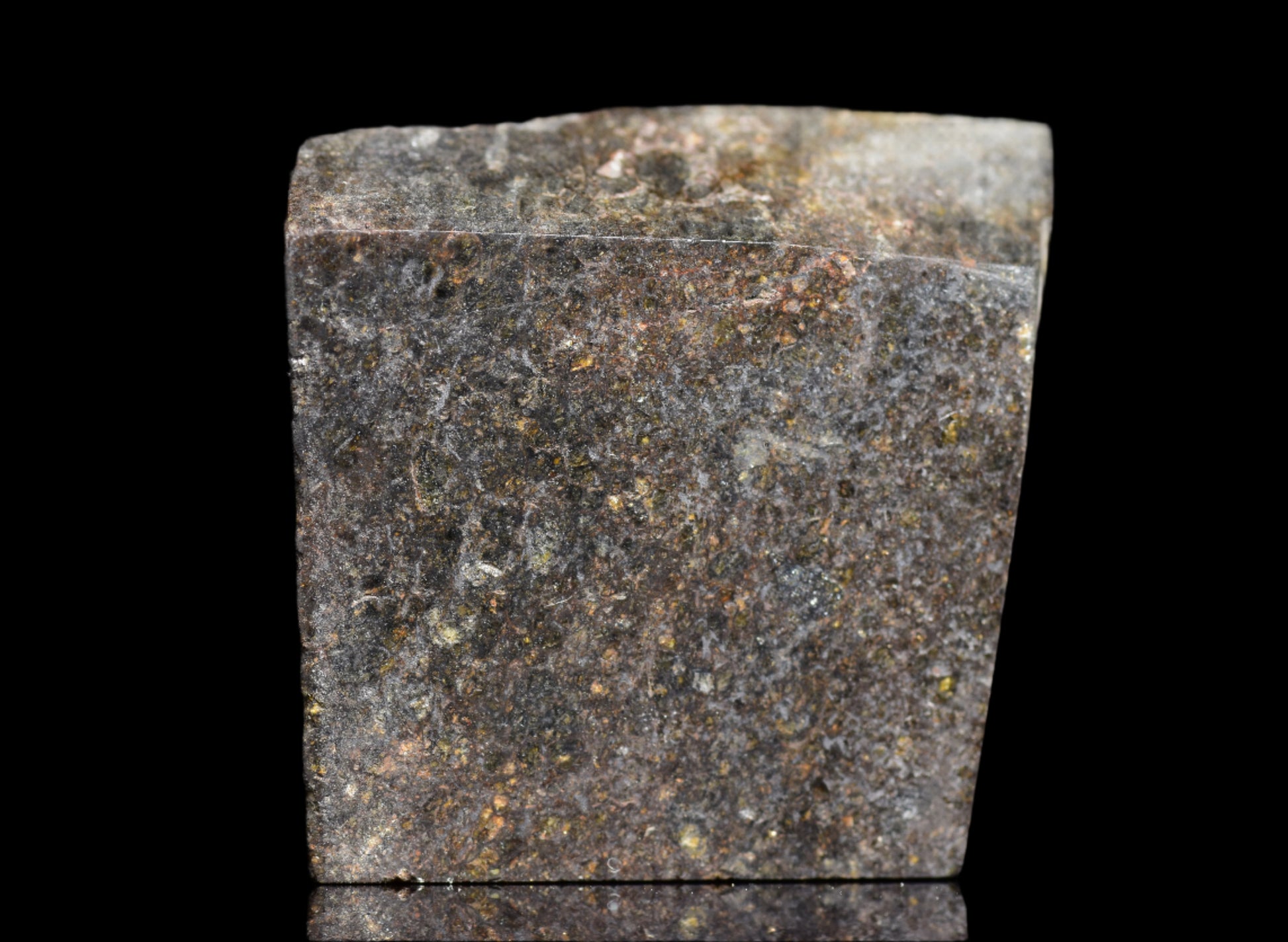 NWA 11757 Ureilite meteorite fragment with dark, metallic surface and mineral textures, weighing 9.9 grams.