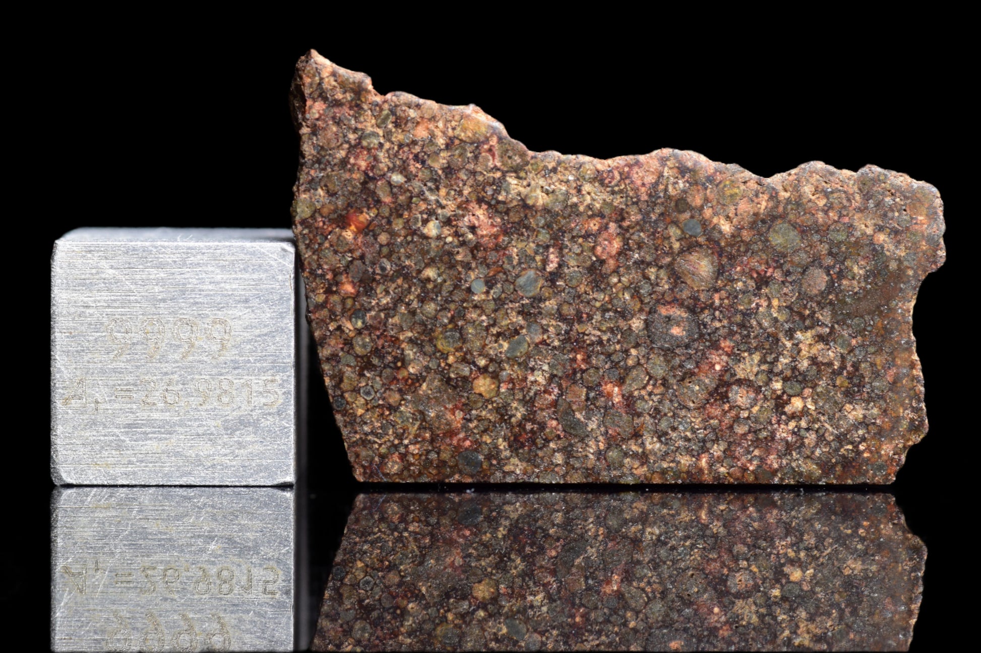 NWA 12341 L3 meteorite sample weighing 2.6 grams, shown with its dark, rocky surface and chondrite texture.