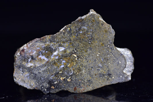 NWA 12344 Eucrite meteorite slice showing dark fusion crust and textured interior, weighed 12.3 grams, from Buy Meteorite, LLC.