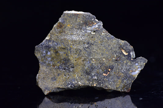 NWA 12344 Eucrite meteorite slice, 2.6 grams, showcasing rough, dark mineral textures on the surface.