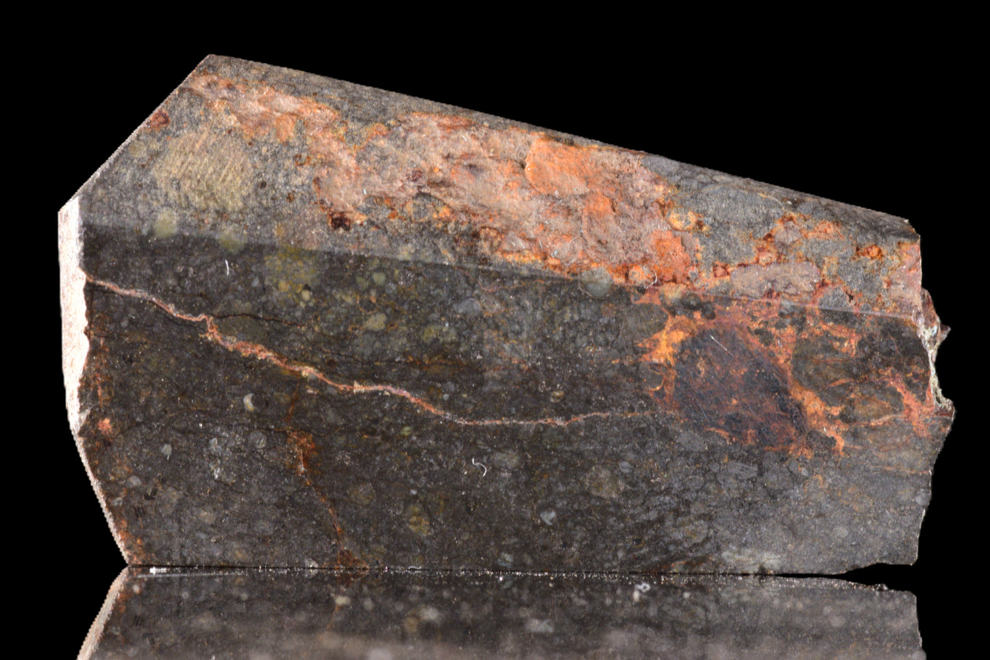 Close-up of NWA 14224 LL3 meteorite slice weighing 6.55 grams, showcasing its textured, dark metallic surface.