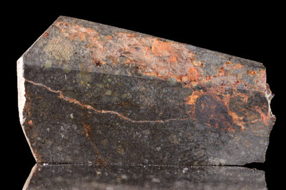 Close-up of NWA 14224 LL3 meteorite slice weighing 6.55 grams, showcasing its textured, dark metallic surface.