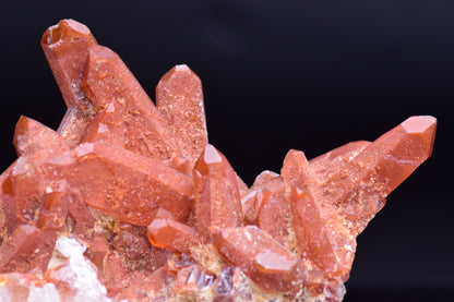 Large red quartz crystal cluster with ferruginous inclusions from Tinejdad, Morocco, showcasing vibrant mineral formations.