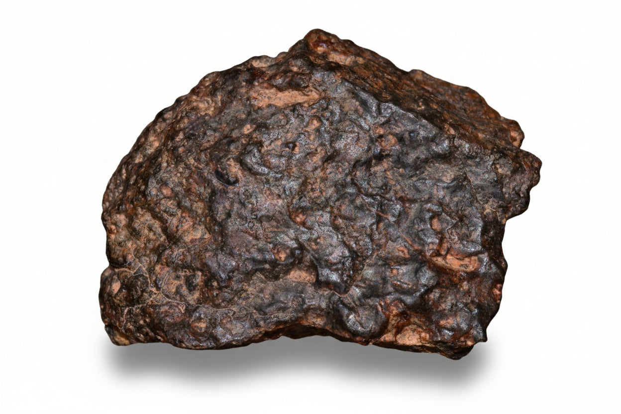 Complete 11.5g NWA 13272 ungrouped achondrite meteorite fragment showing a dark, irregular natural rock piece with rough surface texture.