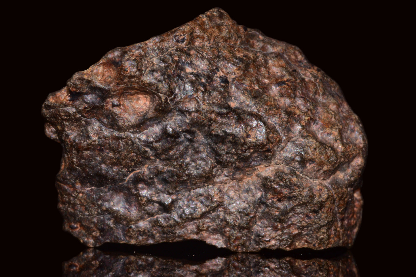 Natural NWA 13272 ungrouped achondrite meteorite fragment, 11.5g, showcasing rough rock surface and unique geological features.