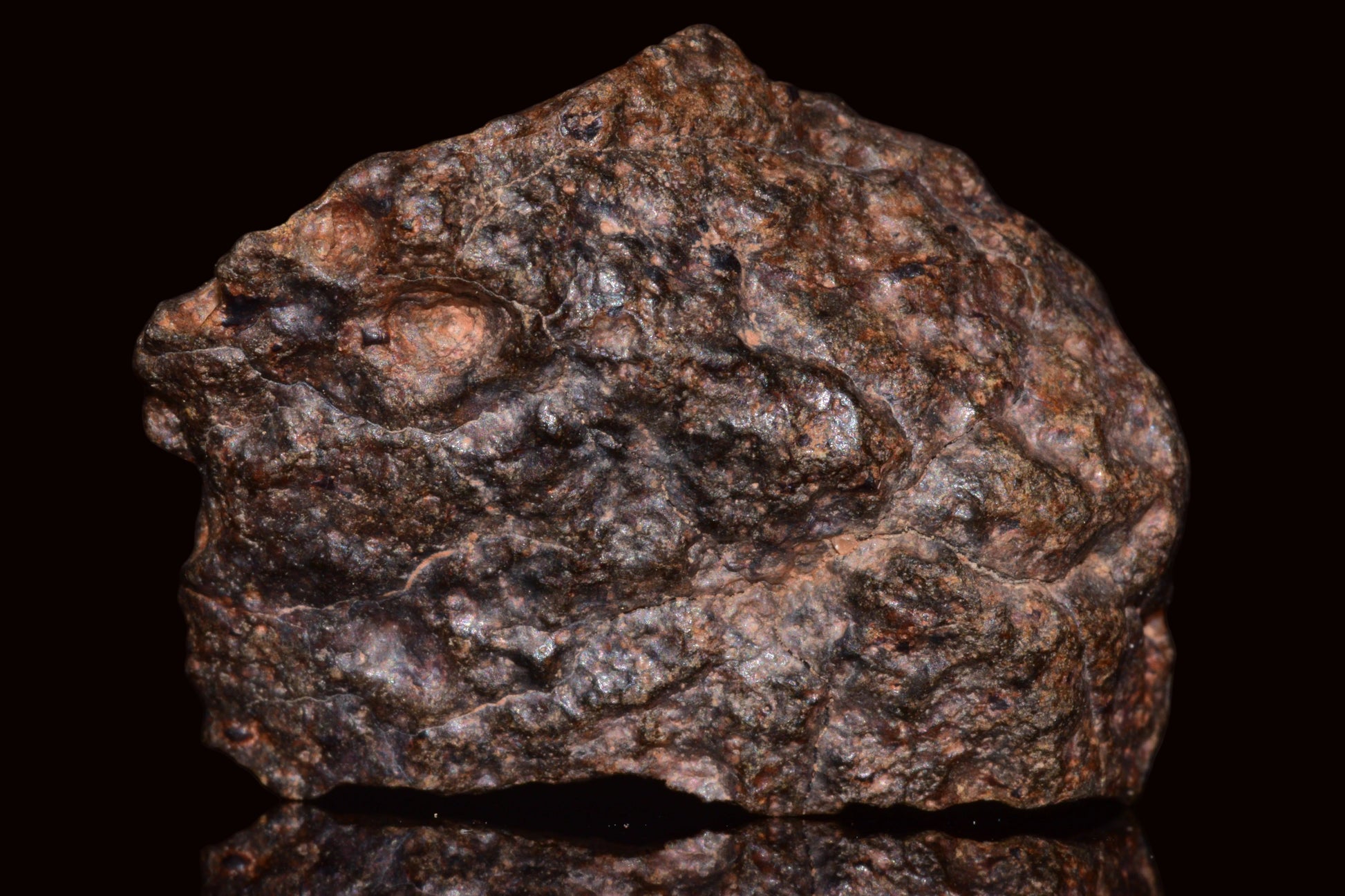 Natural NWA 13272 ungrouped achondrite meteorite fragment, 11.5g, showcasing rough rock surface and unique geological features.